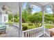 Charming covered porch with wicker seating and ceiling fan overlooking the lush landscaped front yard at 3109 Country Lake Dr, Powder Springs, GA 30127