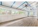 Inviting sunroom with many windows, natural light, wood floor, white wainscoting and a white bench at 3109 Country Lake Dr, Powder Springs, GA 30127