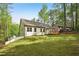 Wide shot of the backyard showing a beautiful lawn, wooden deck, and lots of trees at 2279 Lakeview Pkwy, Villa Rica, GA 30180
