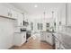 Modern kitchen boasts white cabinets, stainless steel appliances, granite countertops, and hardwood floors at 2279 Lakeview Pkwy, Villa Rica, GA 30180