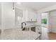 A kitchen island sink highlights granite countertops, white cabinets, and herringbone tile backsplash at 2279 Lakeview Pkwy, Villa Rica, GA 30180