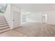 Open-concept living area with neutral carpet, white walls, and a staircase to the left at 2279 Lakeview Pkwy, Villa Rica, GA 30180