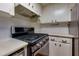 Updated kitchen featuring modern appliances, white cabinets, and a sleek black cooktop at 301 Lakemoore Ne Dr # B, Atlanta, GA 30342