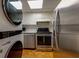 Modern kitchen with stainless steel appliances, white cabinets, and a washer/dryer combo at 301 Lakemoore Ne Dr # B, Atlanta, GA 30342