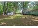 Large backyard showing a deck, an outbuilding and fence line, surrounded by mature shade trees at 3710 Lavilla Dr, Powder Springs, GA 30127