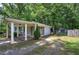 Grey house exterior with carport and lush green lawn and a detached garage at 3710 Lavilla Dr, Powder Springs, GA 30127