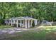 View of charming one-story house, with covered entrance, lush lawn, and mature trees at 3710 Lavilla Dr, Powder Springs, GA 30127