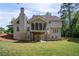 Back exterior with screened porch above and level backyard at 4585 Lakefield Bnd, Berkeley Lake, GA 30096