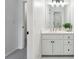 Bathroom featuring vanity, white cabinets with black knobs, mirror and light fixture at 4585 Lakefield Bnd, Berkeley Lake, GA 30096