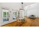 Sunlit dining area with hardwood floors, direct access to an outdoor deck and adjacent to living area at 4585 Lakefield Bnd, Berkeley Lake, GA 30096