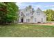 Elegant two-story home featuring a manicured lawn and classic architectural details and lush landscaping at 4585 Lakefield Bnd, Berkeley Lake, GA 30096