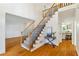 Bright foyer showcases hardwood floors, a staircase with iron railings, and views into the kitchen at 4585 Lakefield Bnd, Berkeley Lake, GA 30096