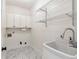 Laundry room with white cabinets, utility sink and marble flooring at 4585 Lakefield Bnd, Berkeley Lake, GA 30096