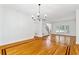 Bright living room with hardwood floors, elegant chandelier, and large windows offering natural light at 4585 Lakefield Bnd, Berkeley Lake, GA 30096