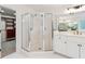 Bright main bathroom with glass-enclosed shower and & sink vanity at 4585 Lakefield Bnd, Berkeley Lake, GA 30096