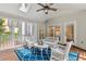 Relaxing sunroom features wicker furniture, skylights, and views of the surrounding trees and blue rug at 4585 Lakefield Bnd, Berkeley Lake, GA 30096
