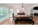 Bright dining room with wood floors, a farmhouse table, and large windows overlooking the backyard at 4739 Bradford Ln, Powder Springs, GA 30127