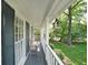 Cozy covered porch with a wooden bench, offering a relaxing outdoor space with a view of the landscaped yard at 4739 Bradford Ln, Powder Springs, GA 30127