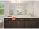 Bright bathroom featuring a large mirror and double vanity with dark wood cabinets at 242 Fieldbrook Xing, Canton, GA 30115