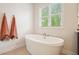 Bright bathroom featuring a standalone tub and a window at 242 Fieldbrook Xing, Canton, GA 30115