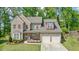 Beautiful two-story brick home with manicured lawn and attached two-car garage at 242 Fieldbrook Xing, Canton, GA 30115