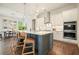 Bright, modern kitchen with stainless steel appliances, white cabinetry, a central island, and pendant lights over a hardwood floor at 242 Fieldbrook Xing, Canton, GA 30115