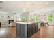 Kitchen island with seating and stainless steel appliances in an open concept area next to a living room at 242 Fieldbrook Xing, Canton, GA 30115
