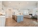 Open kitchen with a stone countertop island and hardwood floor and view to an open living room at 242 Fieldbrook Xing, Canton, GA 30115