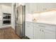 Well-lit kitchen showcasing stainless steel appliances, white cabinetry, plenty of counter space, and hardwood flooring at 242 Fieldbrook Xing, Canton, GA 30115