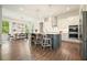 Kitchen featuring white cabinets, a gray island with seating, pendant lighting, and stainless steel appliances next to a dining area at 242 Fieldbrook Xing, Canton, GA 30115