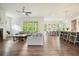 Open-concept living room featuring hardwood floors, a ceiling fan, and lots of natural light from the adjacent kitchen and dining area at 242 Fieldbrook Xing, Canton, GA 30115