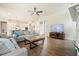 Inviting living room with a cozy sofa, modern ceiling fan, a TV, and an open view of the kitchen and hardwood floors at 242 Fieldbrook Xing, Canton, GA 30115
