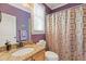 Charming bathroom with granite countertop vanity, patterned shower curtain, and purple accent walls at 2853 N Thompson Ne Rd, Brookhaven, GA 30319
