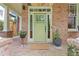 Inviting front entrance features a green door, brick facade, and decorative potted plants at 2853 N Thompson Ne Rd, Brookhaven, GA 30319