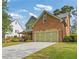 Side view of a brick home showcasing the three-car garage and green lawn at 2853 N Thompson Ne Rd, Brookhaven, GA 30319