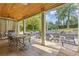 Inviting outdoor patio with wood ceiling, stone floor, dining area, lounge chairs, and a serene pool view at 2853 N Thompson Ne Rd, Brookhaven, GA 30319