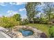 Beautiful backyard oasis with a freeform pool, spa, stone waterfall feature, and surrounding lush landscaping at 2853 N Thompson Ne Rd, Brookhaven, GA 30319