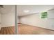 Spacious basement with modern wood-look flooring, white walls, support column, and natural light from window at 2350 Maxine Se Dr, Marietta, GA 30067
