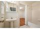 Bathroom featuring a pedestal sink, a tub with white tile surround, and a view to bedroom at 2350 Maxine Se Dr, Marietta, GA 30067