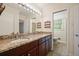Bathroom with double sinks, granite countertop, and dark wood cabinetry with large, decorative mirror and updated fixtures at 2350 Maxine Se Dr, Marietta, GA 30067