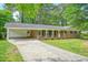 Classic brick home with a convenient carport, well-kept lawn, and mature trees adding to the property's curb appeal at 2350 Maxine Se Dr, Marietta, GA 30067