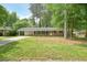 Charming brick home with a covered carport, lush green lawn, and mature trees offering shade and curb appeal at 2350 Maxine Se Dr, Marietta, GA 30067