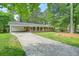 Attractive brick home featuring a carport, well-maintained lawn, and a long driveway, nestled among mature trees at 2350 Maxine Se Dr, Marietta, GA 30067