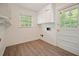 Well-lit laundry room featuring white cabinets, wood-look floors, and a utility sink at 2350 Maxine Se Dr, Marietta, GA 30067