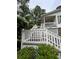 Charming home entrance featuring a wooden porch with white railings and lush greenery at 3701 Shallowford Rd, Marietta, GA 30062