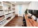 This home office includes hardwood floors, white shelving, and a wooden desk with two monitors at 3701 Shallowford Rd, Marietta, GA 30062