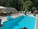 Backyard pool with tanning deck featuring lounge chairs and an umbrella at 3701 Shallowford Rd, Marietta, GA 30062