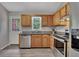 Traditional kitchen featuring wood cabinets, granite countertops, stainless steel appliances, and wood-look flooring at 3812 Stonewall Nw Dr, Kennesaw, GA 30152