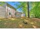 A backyard with mature trees and a view of the back of the house, featuring a patio at 5379 Winslow Xing, Lithonia, GA 30038