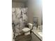 Bathroom with a granite countertop sink, toilet, and a marble-designed shower curtain at 713 Dove Tree Ln, Social Circle, GA 30025